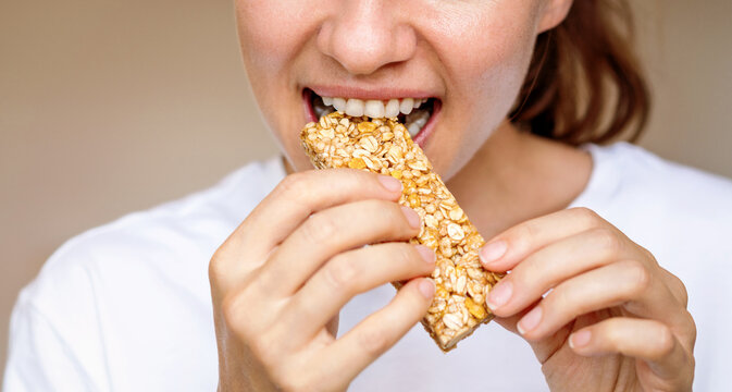 Woman eating protein bar. Healthy diet.