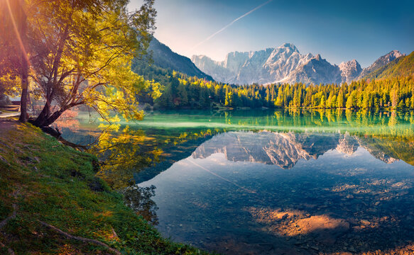 Calm summer scene of Fusine lake. Breathtaking morning view of Julian Alps with Mangart peak on background, Province of Udine, Italy, Europe. Traveling concept background.
