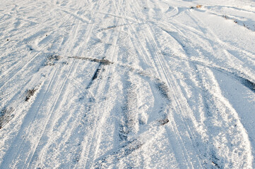 car tire marks on snowy road.