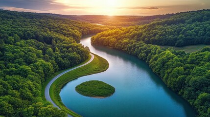 Fototapeta premium Aerial view of a scenic river winding through lush green forests at sunset.