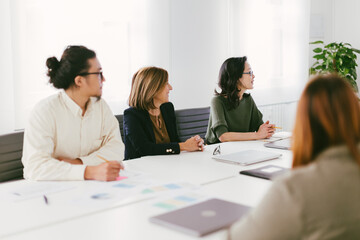 Fototapeta premium A group of people are sitting around a table in a conference room