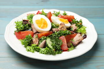Delicious fresh tuna salad on light blue wooden table, closeup