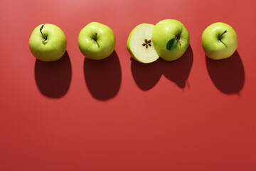 Whole and cut apples on red background, flat lay. Space for text