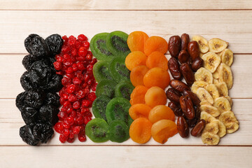 Mix of different dried fruits on wooden table, top view