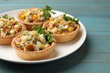 Tartlets with delicious filling on blue wooden table, closeup