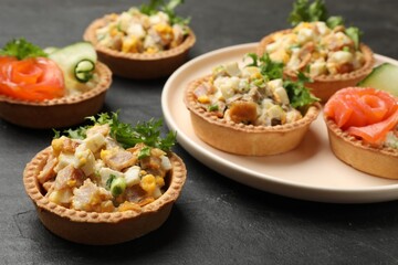 Tartlets with delicious fillings on black table, closeup