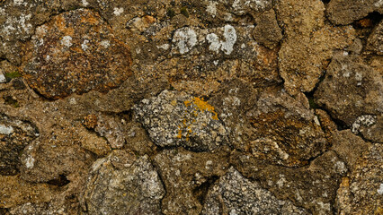 Texture of beige stone wall with rough masonry and uneven surface. Smooth, cracked surface. Old castle wall of stone different shape. Pattern with neutral colors. Minimal, stylish, trend concept.