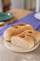 Freshly baked homemade sourdough bread with cherry tomatoes, served on a wooden board, showcasing eco-friendly and hearty artisan baking. 