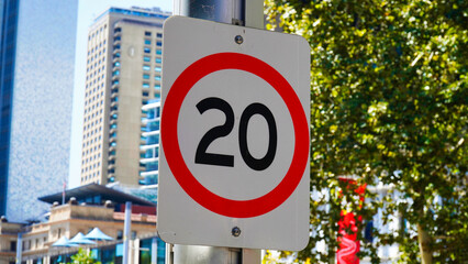 Speed limit sign in urban area indicating a maximum speed of 20 kilometers per hour