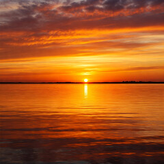 Obraz premium Scarlet-Tinted Clouds Floating Over a Breathtaking Sunset Horizon