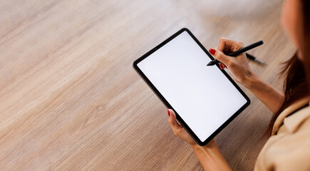 Mockup image of business woman sitting on the wooden table using stylus pen and digital tablet with...