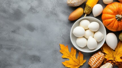 Fresh eggs and autumn produce on gray background.