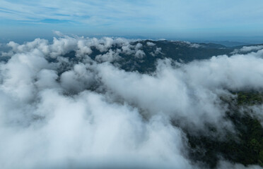 Aerial view Panorama of flowing fog waves on mountain tropical rainforest,Bird eye view image over the clouds Amazing nature background