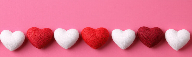 Obraz premium Heart shaped decorations in red and white on pink background