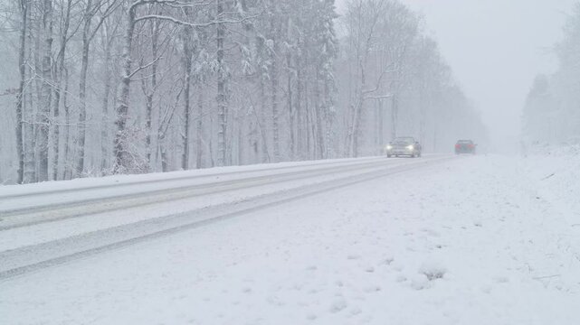 Winter Driving - Mountain road traffic in heavy snowfall - Static shot