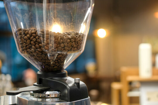 Coffee beans inside the machine hopper at cafe. - Powered by Adobe