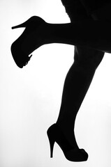 Woman's legs in high heels silhouette black on white isolated