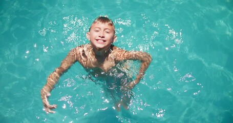 Face, kid and swimming fun in pool, practice skills and outdoor for summer break vacation. Boy, home backyard and portrait for child development in water, fitness and hobby for learning progress