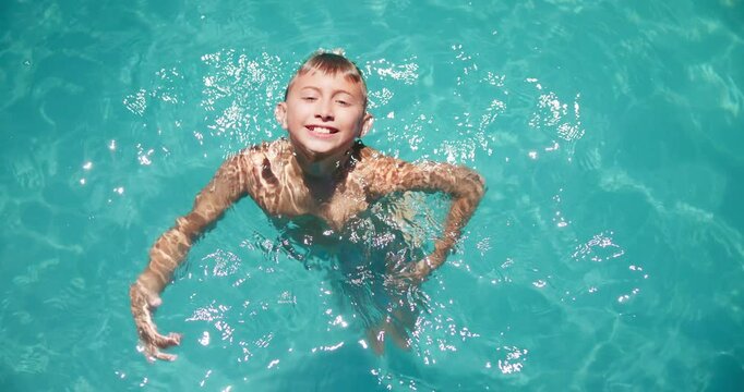 Face, kid and swimming fun in pool, practice skills and outdoor for summer break vacation. Boy, home backyard and portrait for child development in water, fitness and hobby for learning progress