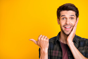 Closeup photo of nice guy indicating thumb to empty space advising best shopping prices wear casual...