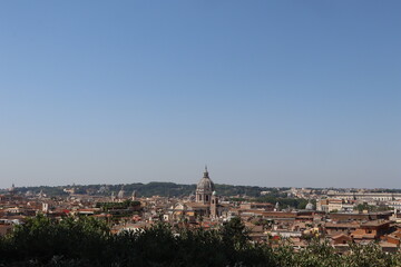 Obraz premium Panoramic view of Rome with historic buildings, domes, and a clear blue sky, showcasing the city's architectural beauty and rich cultural heritage