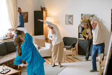 High angle shot of unrecognizable nurse helping elderly people with stretching, they standing in...