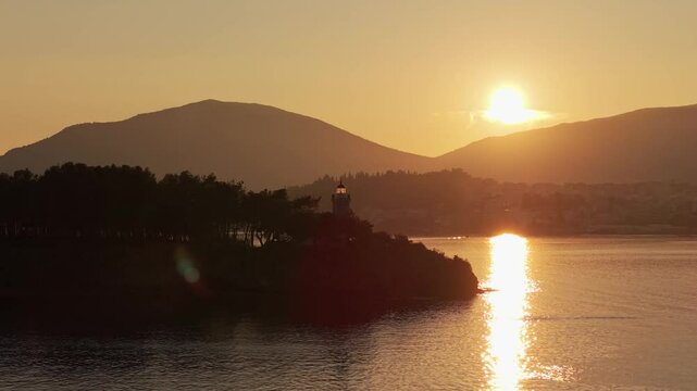 A golden sunset over Chalkida city, with the lighthouse in the foreground