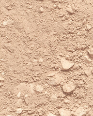 Close-up of a rough, textured stone wall with sand and dirt patterns, showcasing the natural, weathered surface of an old, dry surface with cracks