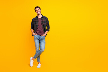 Fototapeta premium Full length body size photo of cheerful charming cute handsome man posing in front of camera with hands in pockets isolated over vivid color background