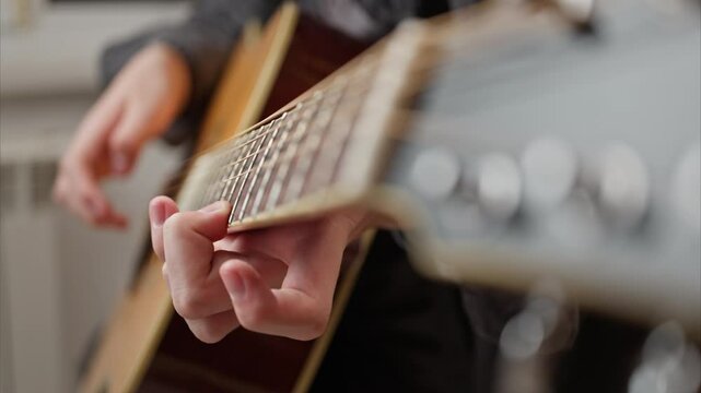 camera on the guitar neck. Smooth focus from the guitar string tuning pegs to the musician's fingers.