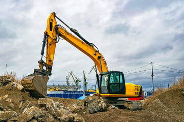 Excavator at work and cranes in the Gdansk Stocznia, old shipyard