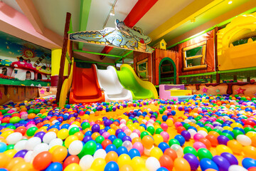 A spacious indoor playground with colorful ball pits and vibrant slides for endless fun.