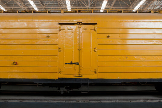 An old yellow train in a train shed.