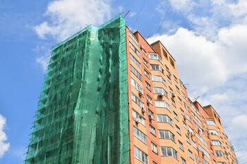 A brick house under construction with wooden scaffolding