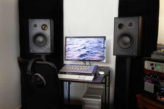 A computer workstation with sound board, speakers, headphones, recording deck and amplifier in a home recording studio