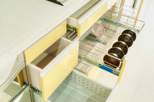 Bowls and dish in a kitchen cupboard with stainless steel racks.