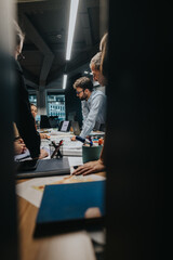 A multicultural group of employees brainstorm and analyze projects around a conference table,...