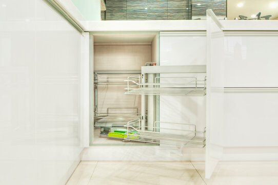 A newly installed modern kitchen with cabinets, two sinks, gas stove, fitted cupboards with red cupboard doors.