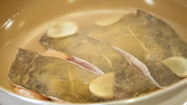 和食の魚の煮付け。新鮮なナメタカレイに調味料をかける動画。