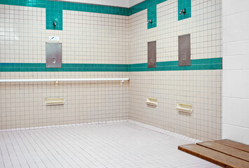 Tiled public shower room for use before entering the swimming pool area at a recreation centre.
