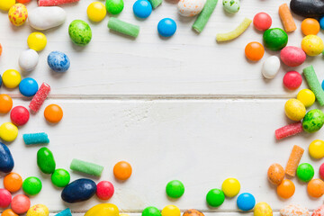 Mixed collection of colorful candy, on colored background. Flat lay, top view. frame of colorful chocolate coated candy