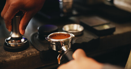 Coffee, portafilter and hands with person, waiter and barista service in cafe with employee for caffeine process. Grounded beans, metal weight and roasted blend for morning brew, hot drink or latte