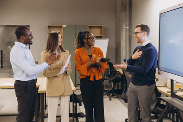 Diverse group of professionals engaging in a collaborative discussion in a modern office environment, showcasing teamwork and innovation