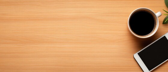 flat lay of a coffee cup and mobile phone on a wooden desk