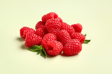 Heap of fresh raspberries and mint on light background