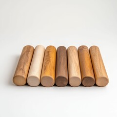 Fototapeta premium A collection of wooden cylinders in varying shades, arranged horizontally against a light background, showcasing natural wood textures.