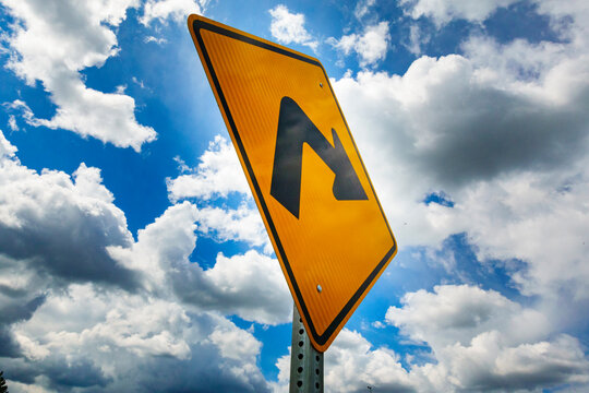Right turn metal road sign, a black arrow on a yellow background.