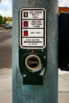 Close up of a road crossing signal information panel and button to press..