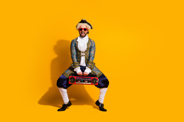Humorous man dressed as a nobleman holding a boombox against a vibrant yellow background