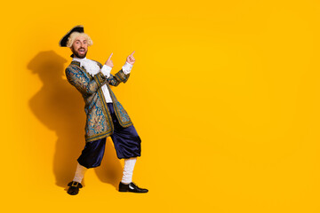 Young man in elegant historical costume posing against a vibrant yellow backdrop